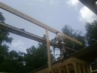 Carpenter setting a ridge beam over a new addition frame — Ice Dam Removal by Roofing Brothers in Broomfield