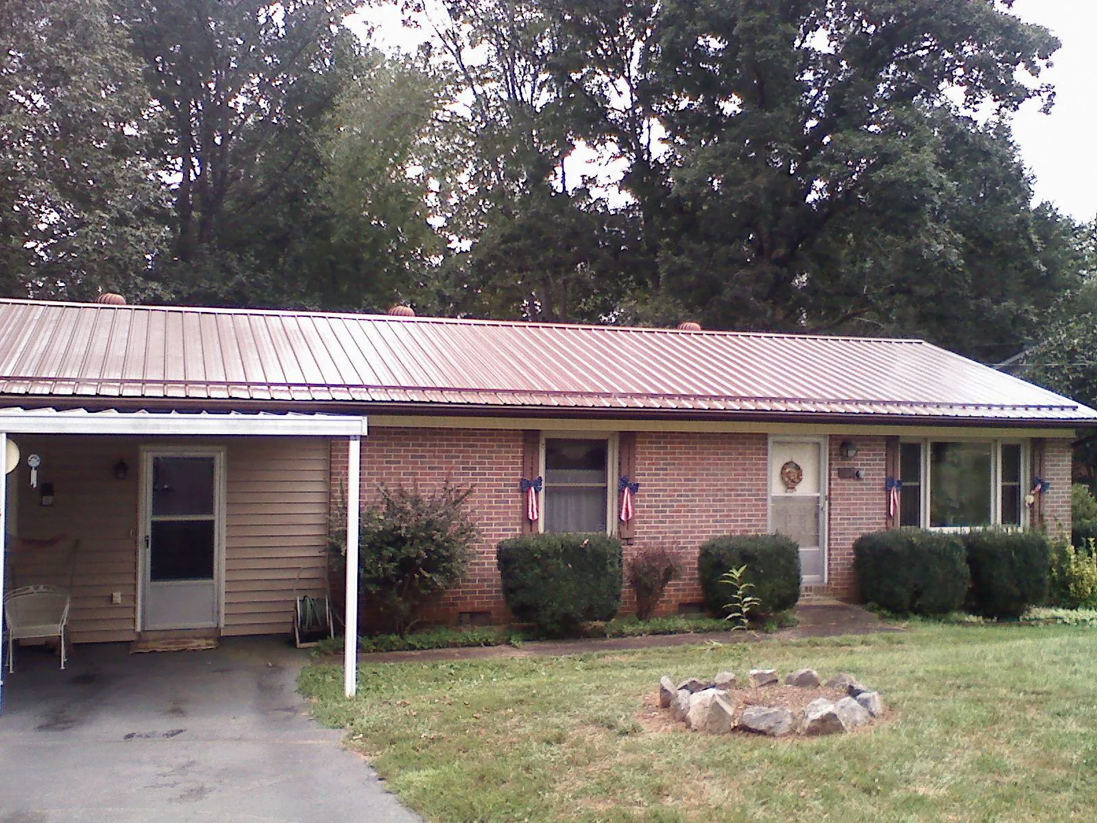 Bronze metal roof and carport on a brick ranch home — Roof Repair work by our crew in Broomfield